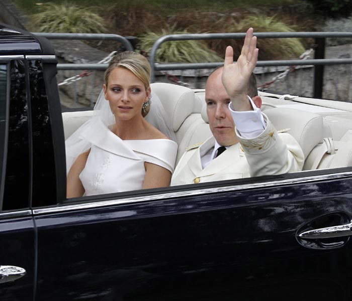 Just Married: Prince Albert II of Monaco and the new Princess Charlene of Monaco wave from their car at the start of their procession.(AFP photo)