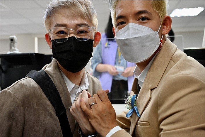 Ting Tse-yen (L) of Taiwan and his partner Leong Chin-fai (L) from Macau pose for photos showing their wedding rings. The couple tied the knot after winning a landmark legal case.