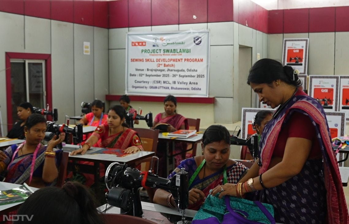 Monalisa Sahu, Usha's Training Officer, demonstrates measurement techniques to a group of tribal learners in Jharsuguda, overcoming language barriers with hands-on methods amid diverse dialects. In a vibrant classroom filled with waste cloth repurposed into home d�cor, her patient guidance elevates basic knowledge to professional levels, enabling women to manage time, orders, and family duties while building a legacy of independence through the MCL-Usha-Gram Utthan collaboration.