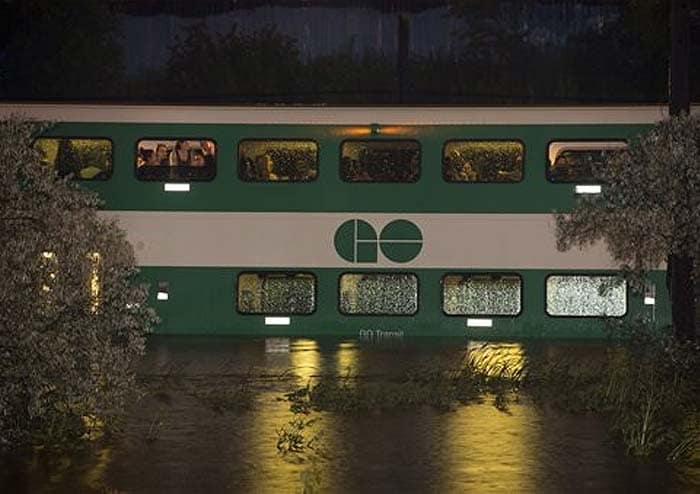 A 10-car, double-decker train stalled in floodwaters that reached up to the lower windows. Murky brown water spilled through the bottom floor of the carriages, sending passengers fleeing to the upper decks