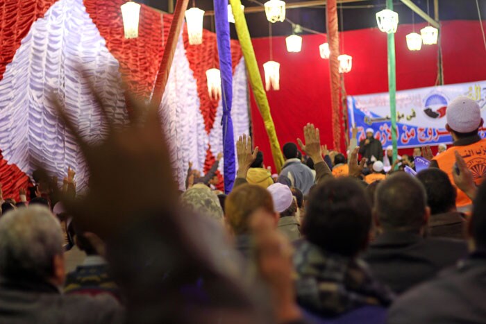 People raise hands at an election rally of the Al Nour Party at a referendum suggesting Sharia law for the country.