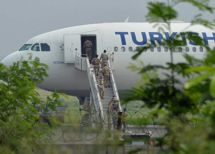 Security officials with a sniffer dog walk onto the plane as it sits on the tarmac at Indira Gandhi International Airport in New Delhi. (AFP Photo)