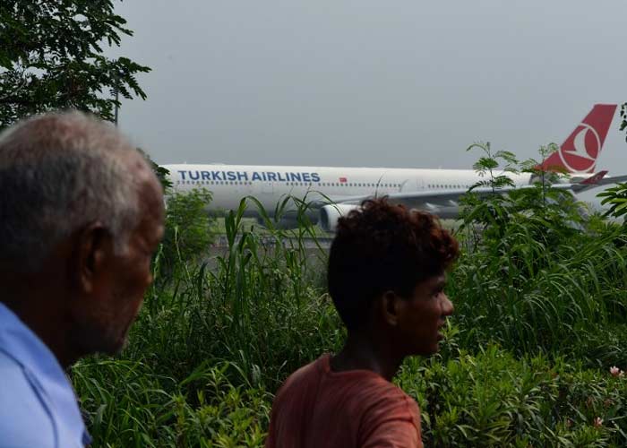 Bystanders look at the Turkish plane after its emergency landing at Indira Gandhi International Airport. (AFP Photo)