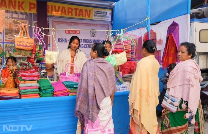 In Dakhinkuchi village near Subankhata, Assam, along the Indo-Bhutan border, women of the Birgwshri Fashion and Home Accessories Unit showcase Bodo Aronai-inspired bags and accessories at the 14th Indo-Bhutan Friendship Fair. Amid bustling stalls and cross-border visitors, participants like Sunita Baro, trained at the Grameen Vikas Manch TCPC funded by HDFC and powered by Usha, demonstrate how collective entrepreneurship bridges cultural ties, generates sustainable income, and empowers women in this harmonious yet opportunity-limited frontier.