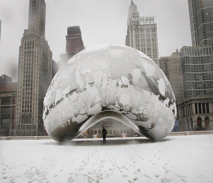 In this picture, a woman takes shelter from the falling snow under Cloud Gate sculpture in Millennium Park, Chicago.(AFP Photo)