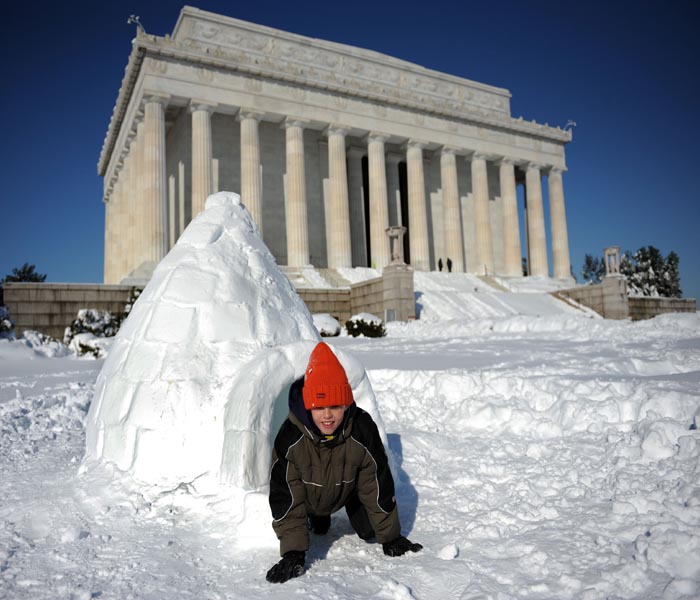 A young boy crawls out of an igloo built near the Lincoln Memorial which remained closed to visitors due to snow and ice as the District of Columbia and the mid-Atlantic region recover from a weekend blizzard.(AFP Photo)