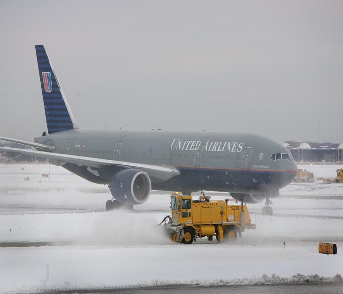 A severe winter storm that dropped 7-12 inches of snow through the Chicago area resulted in cancellation of nearly 600 flights at the city's airports on Monday.<br><br>In this picture, A plow clears snow in front of a United Airlines jet at O'Hare Airport in Chicago, Illinois.(AFP Photo)