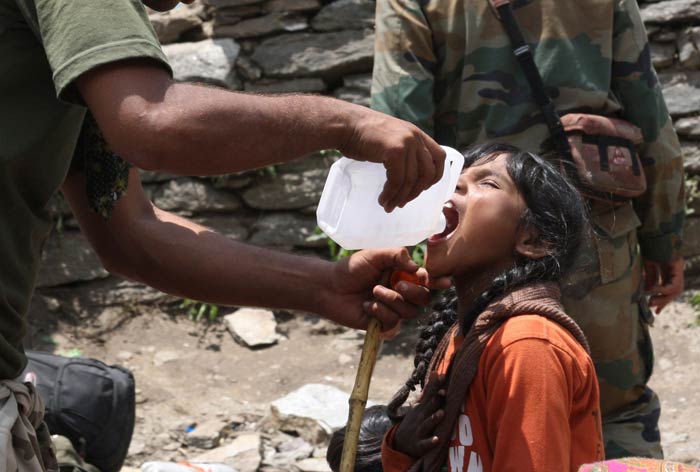 A soldier gives water to a rescued girl in Gauri Kund.<br><br>For more information, go to <a href="http://www.ndtv.com/sos" class="fbld fn fl ">www.ndtv.com/sos</a>