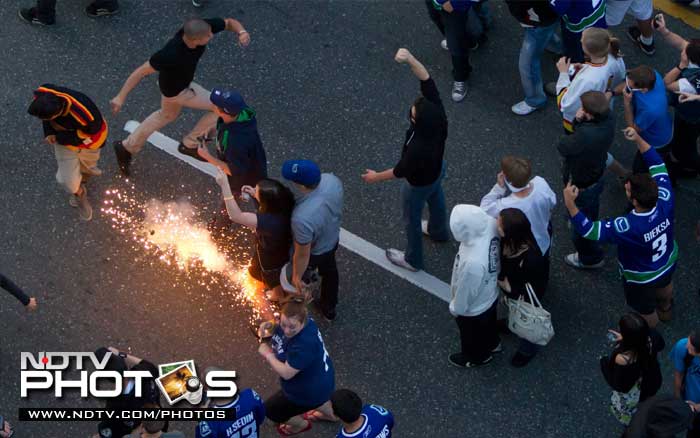 The mob set cars and garbage cans ablaze, smashed windows, showered giant TV screens with beer bottles and danced atop overturned vehicles. (AP Photo)