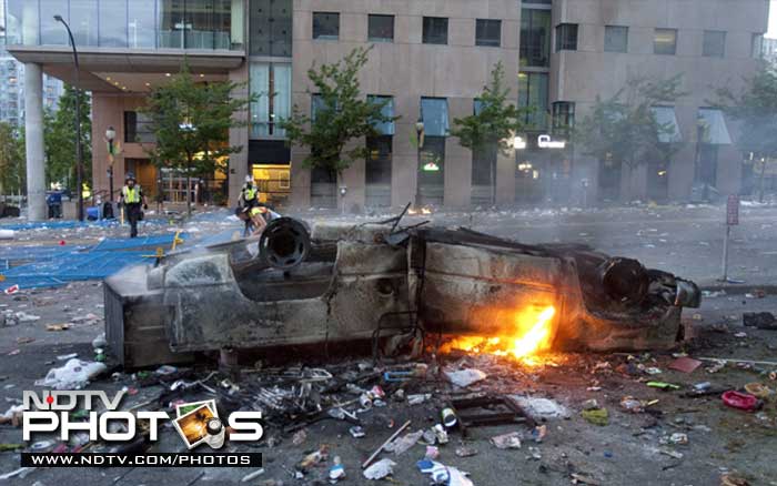 A burnt out car lies upside down in the street following the riots. (AP Photo)