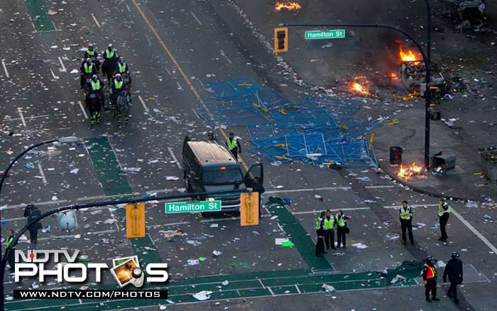 Police officers stand amongst debris after rioters moved through the area. (AP Photo)