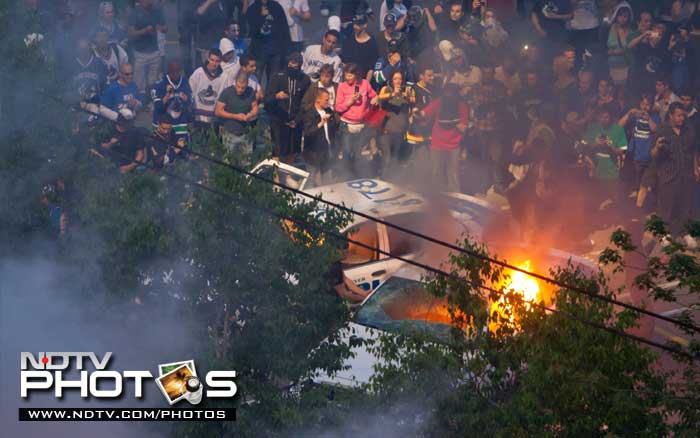 Rioters burn police cars after the Vancouver Canucks were defeated by the Boston Bruins in the NHL's Stanley Cup Final. (AP Photo)