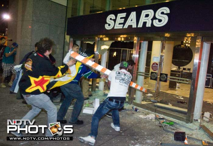 Rioters break the front doors of a Sears department store on Granville Street. (AP Photo)