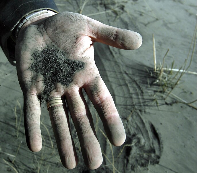 A man displays volcanic ash fallen to ground at Myrdalssandur, some 220km east of the capital Rejkavik, Iceland. (AP Photo)