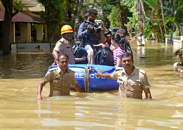 बेंगलुरु में लगातार बारिश के बाद क्षेत्र आंशिक रूप से जलमग्न होने के बाद एक इलाके के निवासियों को अग्निशामकों द्वारा निकाला गया. (पीटीआई फोटो)