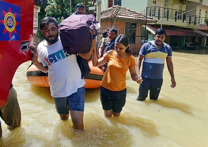 बेंगलुरू में भारी बारिश और जलभराव के बाद सामान शिफ्ट करते लोग.  (पीटीआई फोटो)