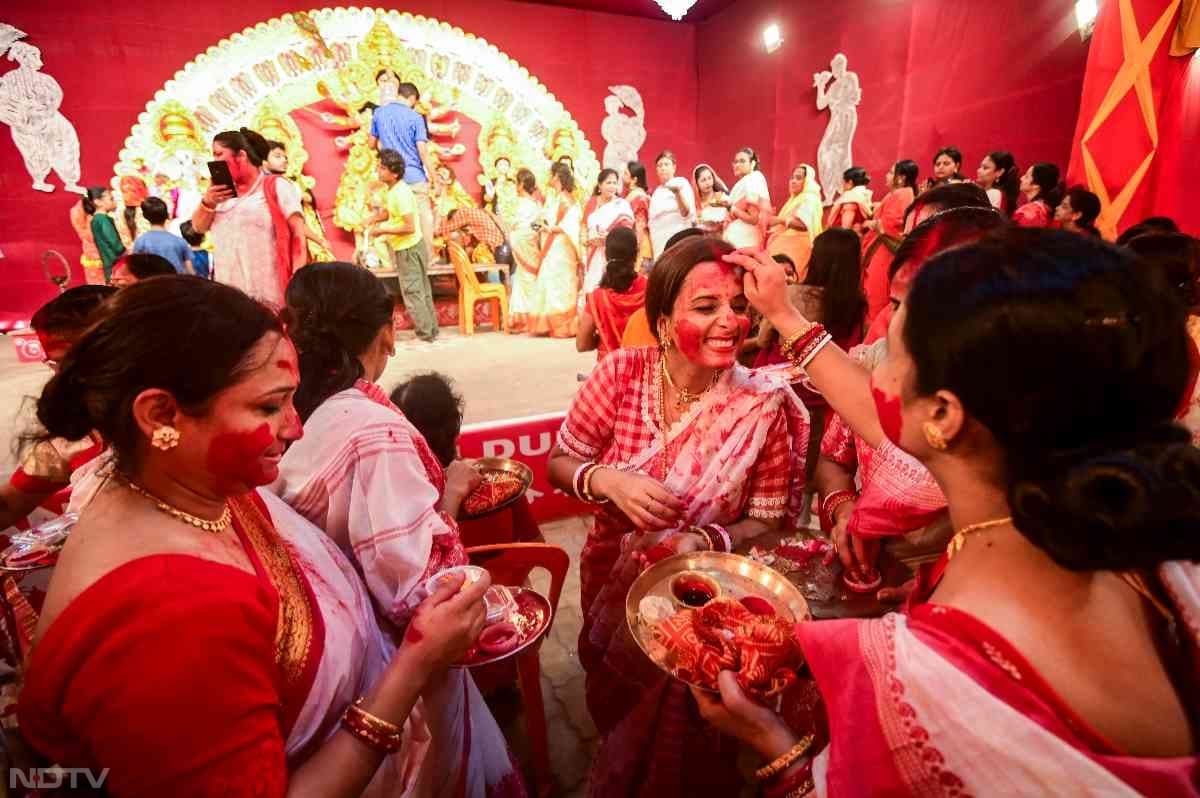 सिंदूर खेला के दौरान सभी महिलाएं एक दूसरे को सिंदूर लगाती हैं.