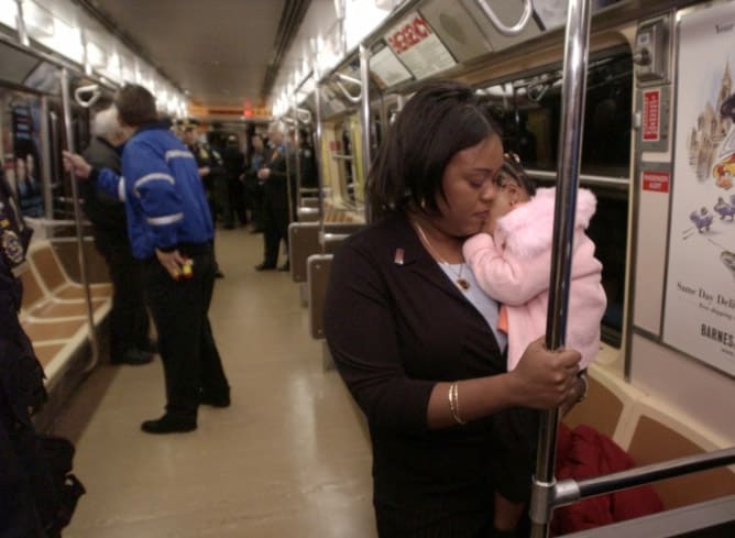 Thelma Stuart of  Valley Stream, Long Island, N.Y., holds her daughter Amanda, on Nov. 23, 2003, as she rides in the front car of the first PATH train to return to the World Trade Center after the station was destroyed Sept. 11, 2001. Staurt's husband, Port Authority police officer Walwyn Stuart Jr., was instrumental in safely evacuating that train, and returning to the trade center, where he died. Regular PATH service between the World Trade Center and New Jersey resumed Sunday. (AP Photo)