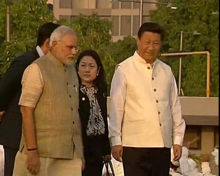 Prime Minister Narendra Modi and China's President Xi Jinping walk to attend a cultural program at the Sabarmati Riverfront.