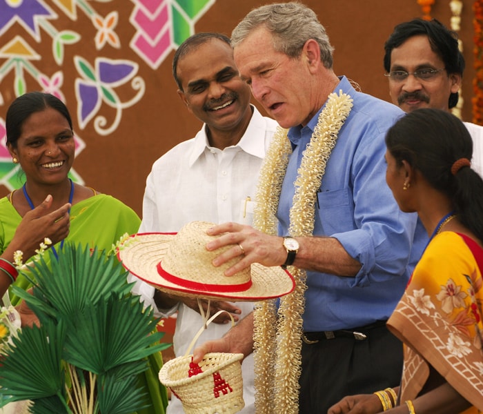 YSR was particularly popular for his welfare schemes, which found no match around the country.<br><br>In this picture taken in 2006, US President George W. Bush (C) looks at a woven hat while on a visit to fibre product exhibition with YSR at the Acharya N.G. Ranga Agricultural University in Hyderabad.<br><br> The University has been partnered with Cornell University in a US Agency for International Development sponsored program designed to stimulate India's agricultural development.