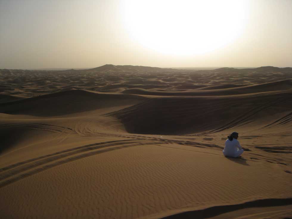 As I walked down the hot, yet cool sand, I spotted an Arabic man sitting in the midst of it all, staring into nothingness.