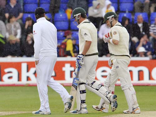 Marcus North and Michael Clarke chat to Graeme Swann as they leave the field for a rain delay on the third day of the first Ashes Test between England and Australia in Cardiff. (AFP Photo) Ashes: 1st Test, Day 3