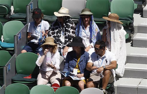 Spectators protect themselves from the sun as they watch Russia's Elena Dementieva play Spain's Carla Suarez Navarroin a women's singles match at the Australian Open in Melbourne on Wednesday. (AP Photo) Australian Open Day 10