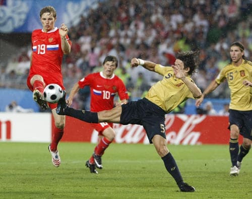 Russia's Roman Pavlyuchenko, left, and Spain's Carles Puyol challenge for the ball during the semifinal match between Russia and Spain in Vienna, Austria. 2nd Semifinal - Russia vs Spain