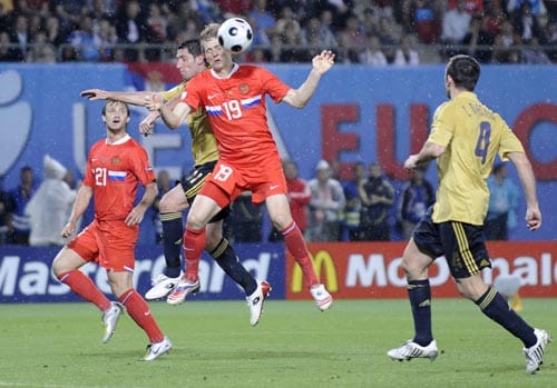 Russia's Roman Pavlyuchenko, foreground, and Spain's Joan Capdevila, second left at rear, challenge for the ball during the semifinal match between Russia and Spain in Vienna, Austria. 2nd Semifinal - Russia vs Spain