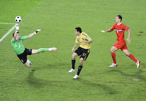 Spain's Daniel Guiza, center, scores his side's 2nd goal past Russia's Igor Akinfeev, left, during the semifinal match between Russia and Spain in Vienna, Austria. 2nd Semifinal - Russia vs Spain