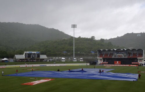 Ground keepers cover the pitch as a rain fall delays the start of the fourth and final One-Day International match between India and the West Indies at Beausejour in St. Lucia. (AP Photo) India win ODI series in WI