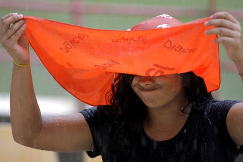A cricket fan reacts with disappointment as rain fall during the fourth and final One-Day International match between India and the West Indies at Beausejour in St. Lucia. (AP Photo) India win ODI series in WI