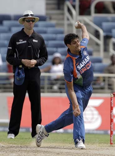 Ashish Nehra bowls against the West Indies, as umpire Nigel Llong looks on, during the first ODI against the West Indies at the Sabina Park. (AP Photo) 1st ODI: IND vs WI