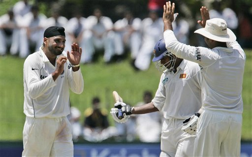 Harbhajan Singh, left, celebrates the dismissal of Sri Lankan batsman Prasanna Jayawardene, center, with teammate V.V.S. Laxman during the third day's play of the first Test cricket match between Sri Lanka and India in Colombo on Friday, July 25, 2008. India vs SL, 1st Test, Day 3