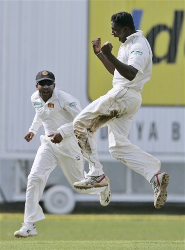 Sri Lankan bowler Ajantha Mendis, right, celebrates his maiden Test wicket with captain Mahela Jayawardene, after dismissing India's Rahul Dravid, unseen, during the third day's play of the first cricket Test match between Sri Lanka and India in Colombo on Friday, July 25, 2008. India vs SL, 1st Test, Day 3