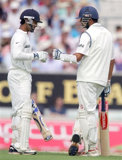 India's Dinesh Karthik, left with Rahul Dravid touch gloves as India pass the 100 run mark as they play England during the first days play at the third cricket test at the Oval in London on Thursday. India vs England, 3rd Test - Day 1