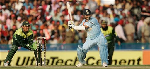 Sachin Tendulkar, right, plays a shot as Pakistan's Kamran Akmal, left, looks on, during the second one day international cricket match in Mohali, India, Thursday, Nov. 8, 2007. Ind v Pak - 2nd ODI