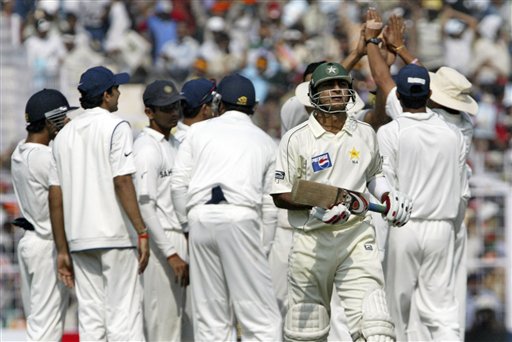 Faisal Iqbal walks out on his dismissal as Indian cricketers celebrate in the background during the third day of the second Test match in Kolkata on Sunday, December 2, 2007. 2nd Test, Ind vs Pak - Day 3