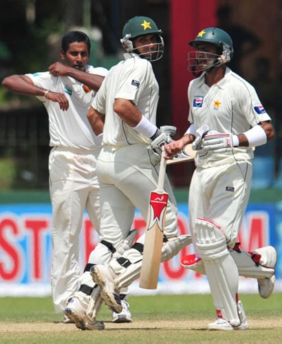 Shoaib Malik and Misbah-ul-Haq run between wickets as Chaminda Vaas looks on during the third and final Test match between Sri Lanka and Pakistan at The Sinhalese Sports Club in Colombo. (AFP Photo) Pak vs SL: 3rd Test, Day 3