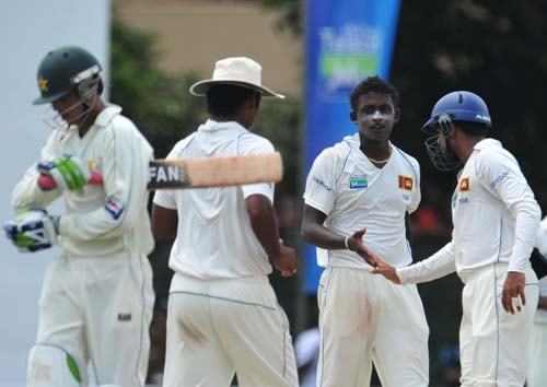 Ajantha Mendis is congratulated by teammate Malinda Warnapura after dismissing Mohammad Aamer during the first day of the second Test match between Pakistan and Sri Lanka at The P. Saravanamuttu Stadium. (AFP Photo) Day 1: Pak vs SL, 2nd Test