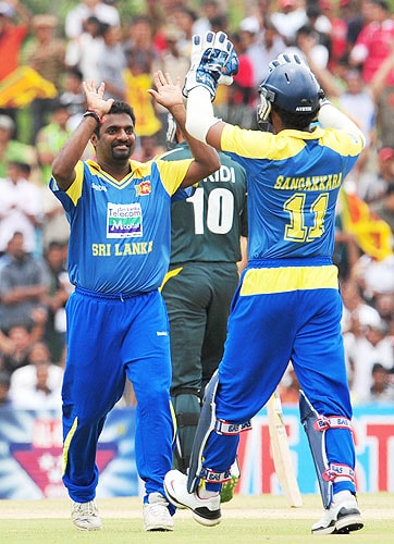 Muttiah Muralitharan celebrates with Kumar Sangakkara the dismissal of Younis Khan during the second One-Day International match between Sri Lanka and Pakistan in Dambulla. (AFP Photo) Pak vs SL: 2nd ODI