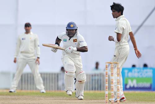 Rangana Herath runs between wickets while watched by Mohammad Aamer during the first Test match between and Sri Lanka at The Galle International Stadium. (AFP Photo) Day 1: Pak vs SL, 1st Test