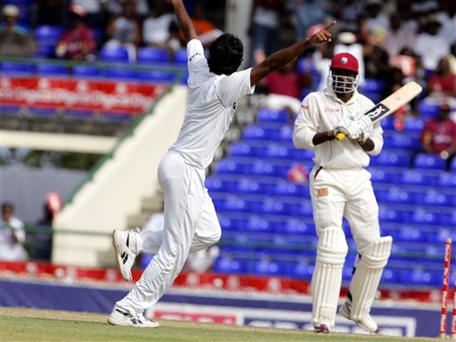 India's bowler Munaf Patel, left, celebrates after bowling West Indies batsman Chris Gayle, right, for 143 for 1 on the first day of the third cricket test match at St. Kitts. Ind-WI 3rd Test Day 1