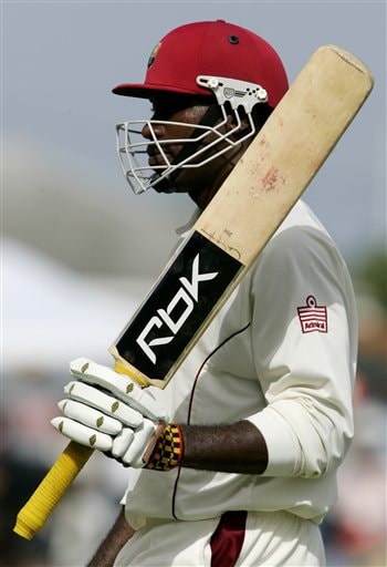 West Indies opening batsman Chris Gayle raises his bat as he walks off the field after being bowled by India's bowler Munaf Patel on the first day of the third cricket test at St. Kitts. Ind-WI 3rd Test Day 1