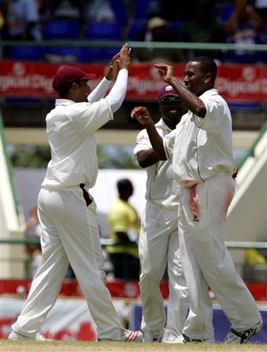 West Indies batsman Corey Collymore, right, is congratulated by Daren Ganga, left, and captain Brian Lara, centre, after taking the wicket of India's batsman Mahendra Dhoni LBW for 220 for 6 on the fourth day of the third cricket Test match at Warner Park in Basseterre, St Kitts, Sunday, June 25, 2006. (AP Photo/Lynne Sladky) Ind-WI 3rd Test Day 4