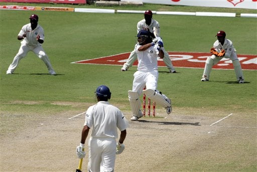 India's batsman Mahendra Dhoni, centre, hits a boundary against the West Indies on the fourth day of the third cricket Test match at Warner Park in Basseterre, St Kitts, Sunday, June 25, 2006. (AP Photo/Lynne Sladky) Ind-WI 3rd Test Day 4