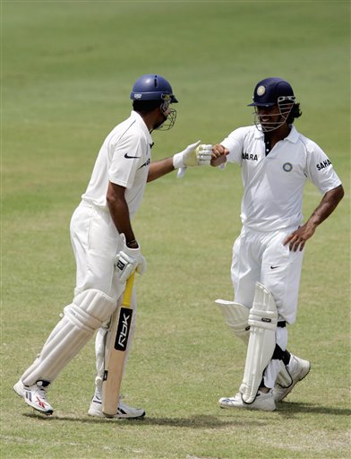 India's batsmen VVS Laxman, left, and Mahendra Dhoni, right, bump their fists together as they prepare to resume batting against the West Indies on the fourth day of the third cricket Test match at Warner Park in Basseterre, St Kitts, Sunday, June 25, 2006. (AP Photo/Lynne Sladky) Ind-WI 3rd Test Day 4