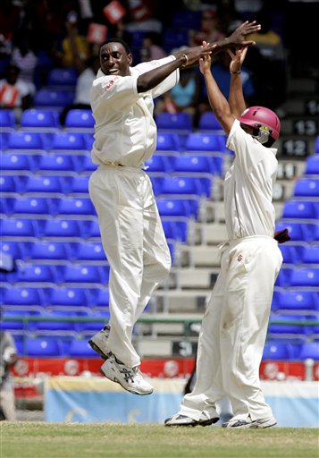 West Indies bowler Pedro Collins, left, celebrates with Ramnaresh Sarwan after taking the wicket of India's batsman Shanthakumaran Sreesanth for 315 for 9 on the fourth day of the third cricket Test match at Warner Park in Basseterre, St Kitts, Sunday, June 25, 2006. (AP Photo/Lynne Sladky) Ind-WI 3rd Test Day 4