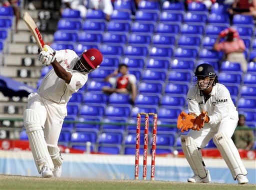 West Indies captain Brain Lara, left, hits a six off the bowling of India's bowler Anil Kumble (not shown) in the second inning on the fourth day of the third cricket Test match at Warner Park in Basseterre, St Kitts, Sunday, June 25, 2006. At right is India's wicketkeeper Mahendra Dhoni. (AP Photo/Lynne Sladky) Ind-WI 3rd Test Day 4