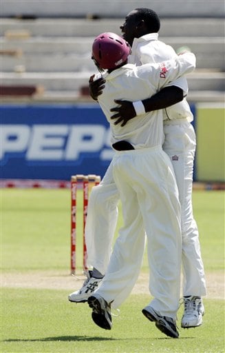 West Indies bowler Pedro Collins, right, hugs Ramanresh Sarwan, left, after Sarwan caught India's batsman Virender Sehwag for the first wicket during the fourth Test match at Kingston. Ind-WI 4th Test Day 1